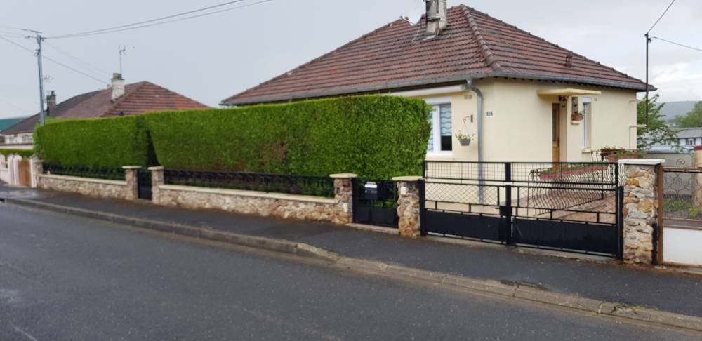 Vue extérieure d'une maison avec une haie