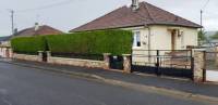 Vue extérieure d'une maison avec une haie